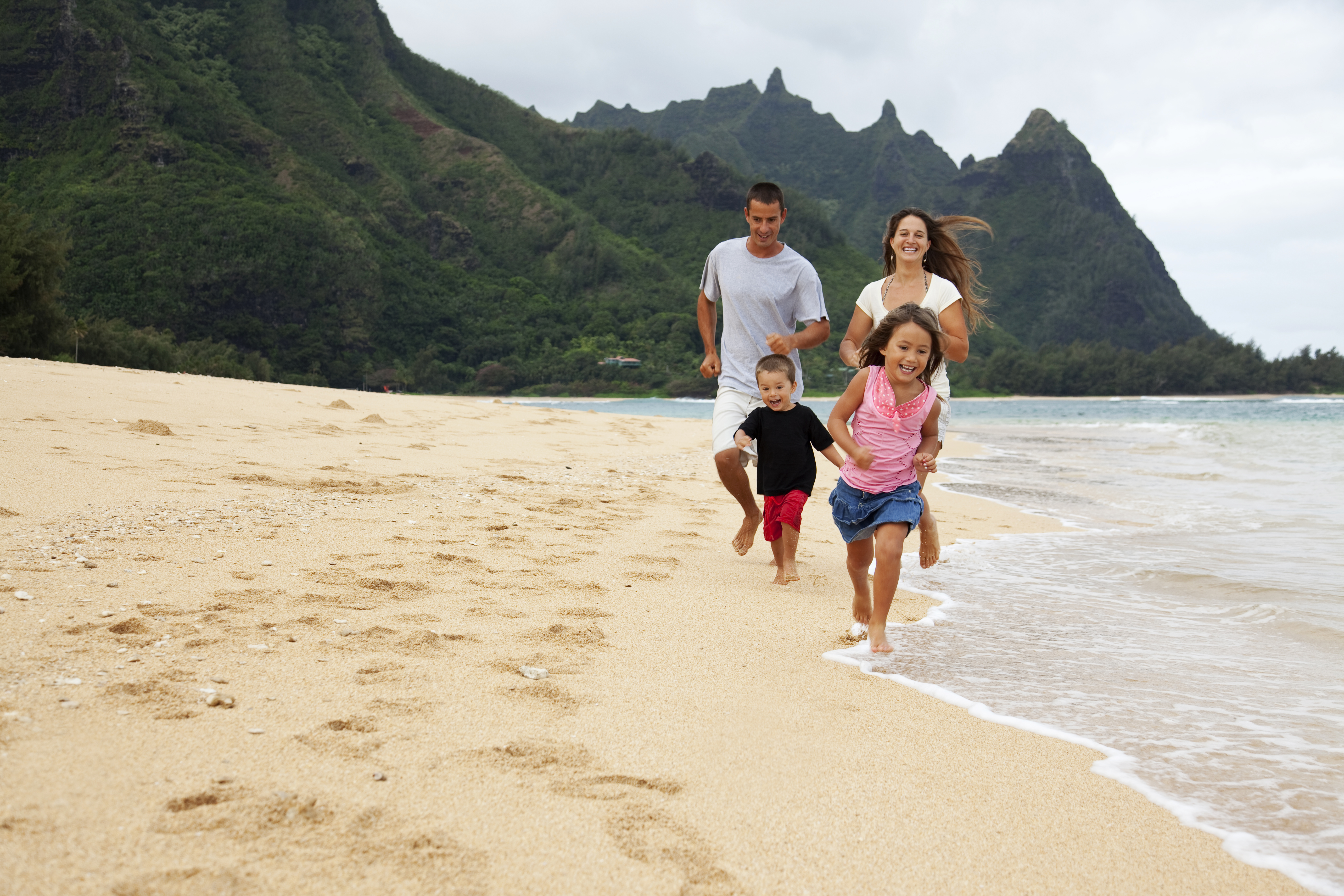 Family running on a beach on Kauai